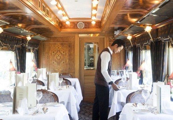 Waiters setting the table for lunch service on the Eastern & Oriental Express.